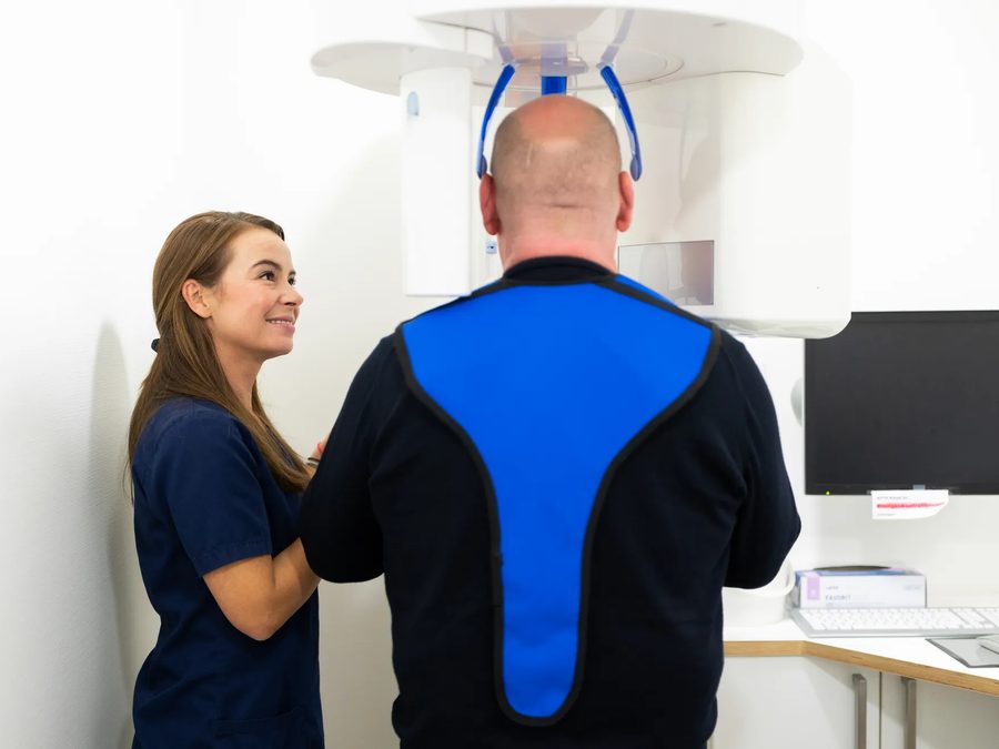 Kollegin bereitet ein Röntgenbild mit einem Patienten vor